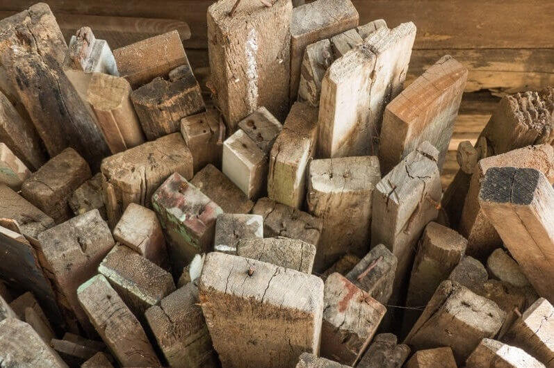 Holzentsorgung – Fachgerechte Entsorgung von Holzabfällen und Altholz für nachhaltige Entsorgungslösungen Holzbalken stehend nebeneinander