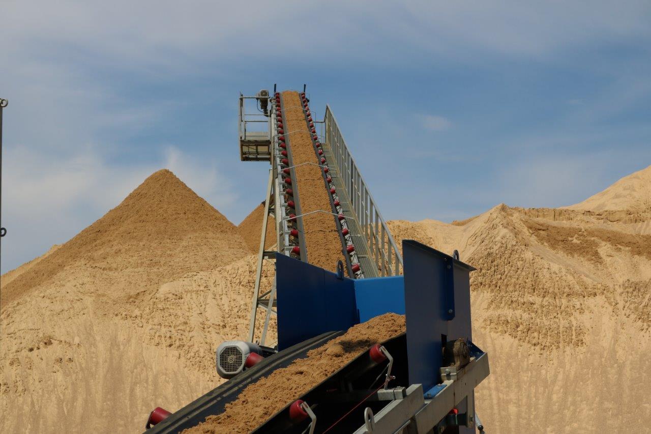 Förderband auf Deponie Ein Förderband transportiert Sand